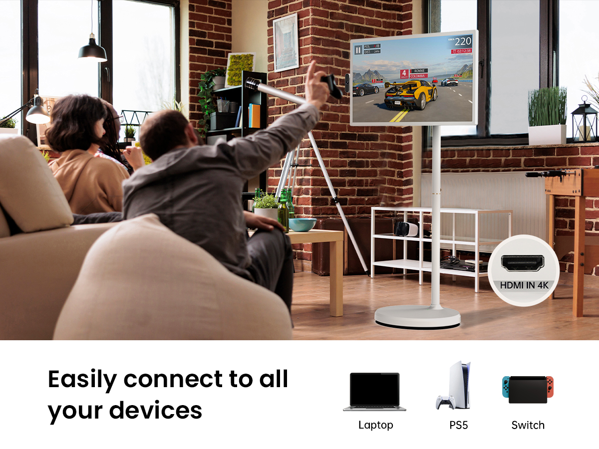 A couple is playing a racing game on a stand-mounted Portable TV that supports 4K HDMI connection to devices like Laptop, PS5, and Switch.