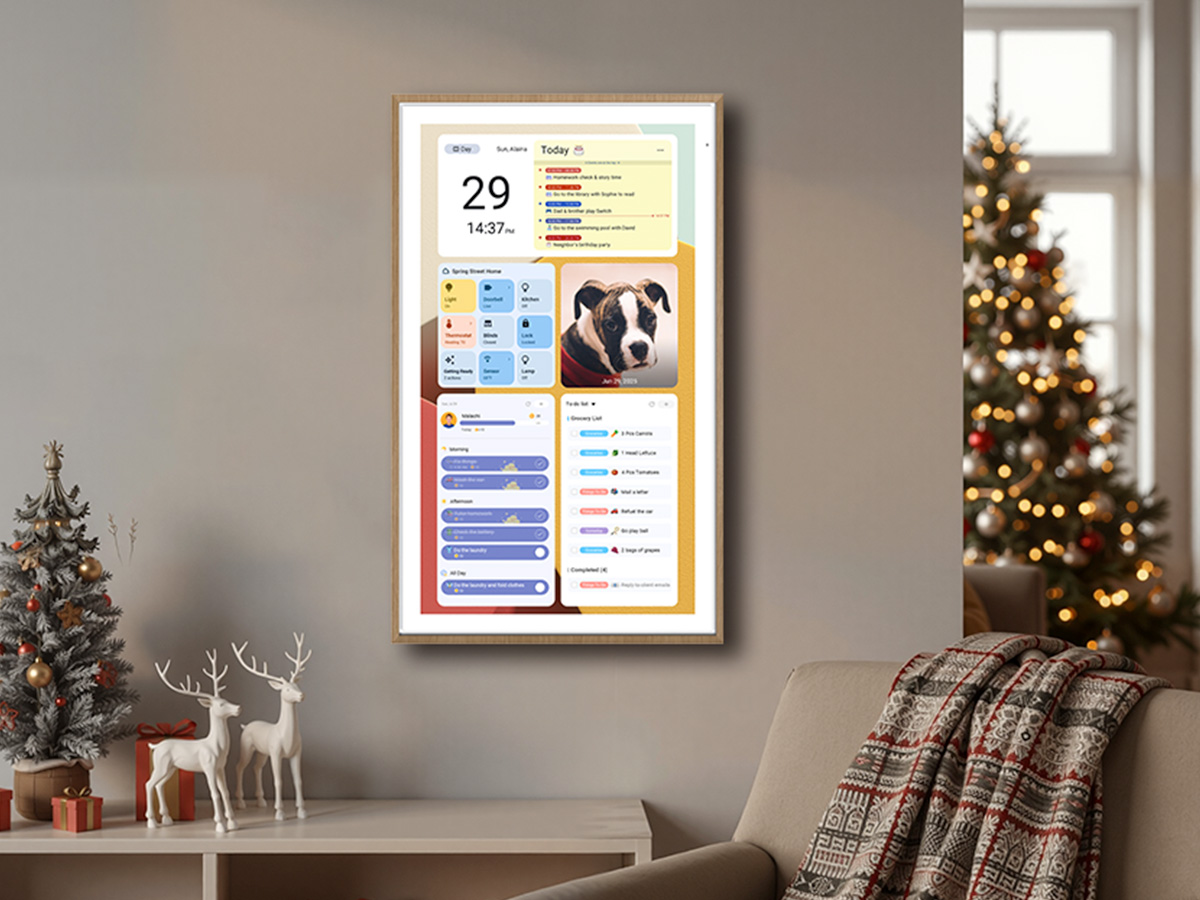 Digital family wall calendar display showing daily schedule, task widgets, weather forecast, and pet photo in modern living room with Christmas decorations