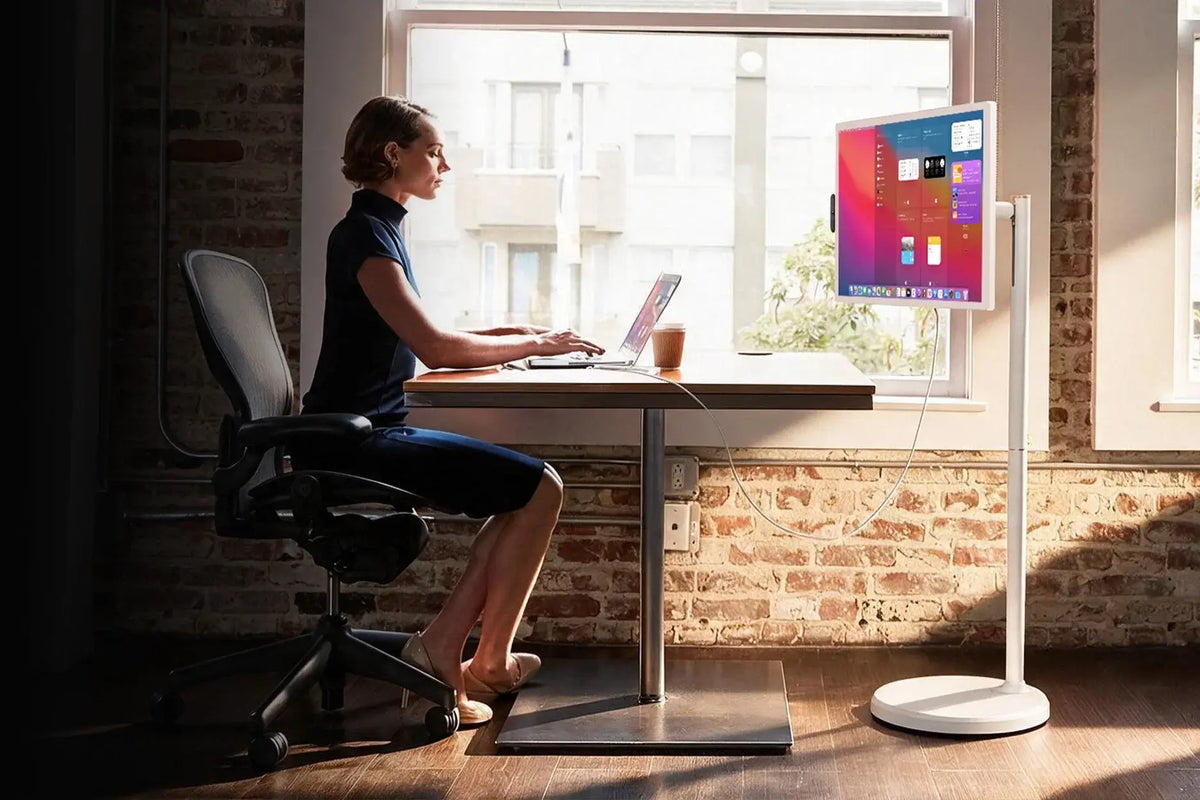 Apolosign portable TV, freely‑movable smart screen with screen‑casting feature, woman casting laptop content while working at home‑office desk